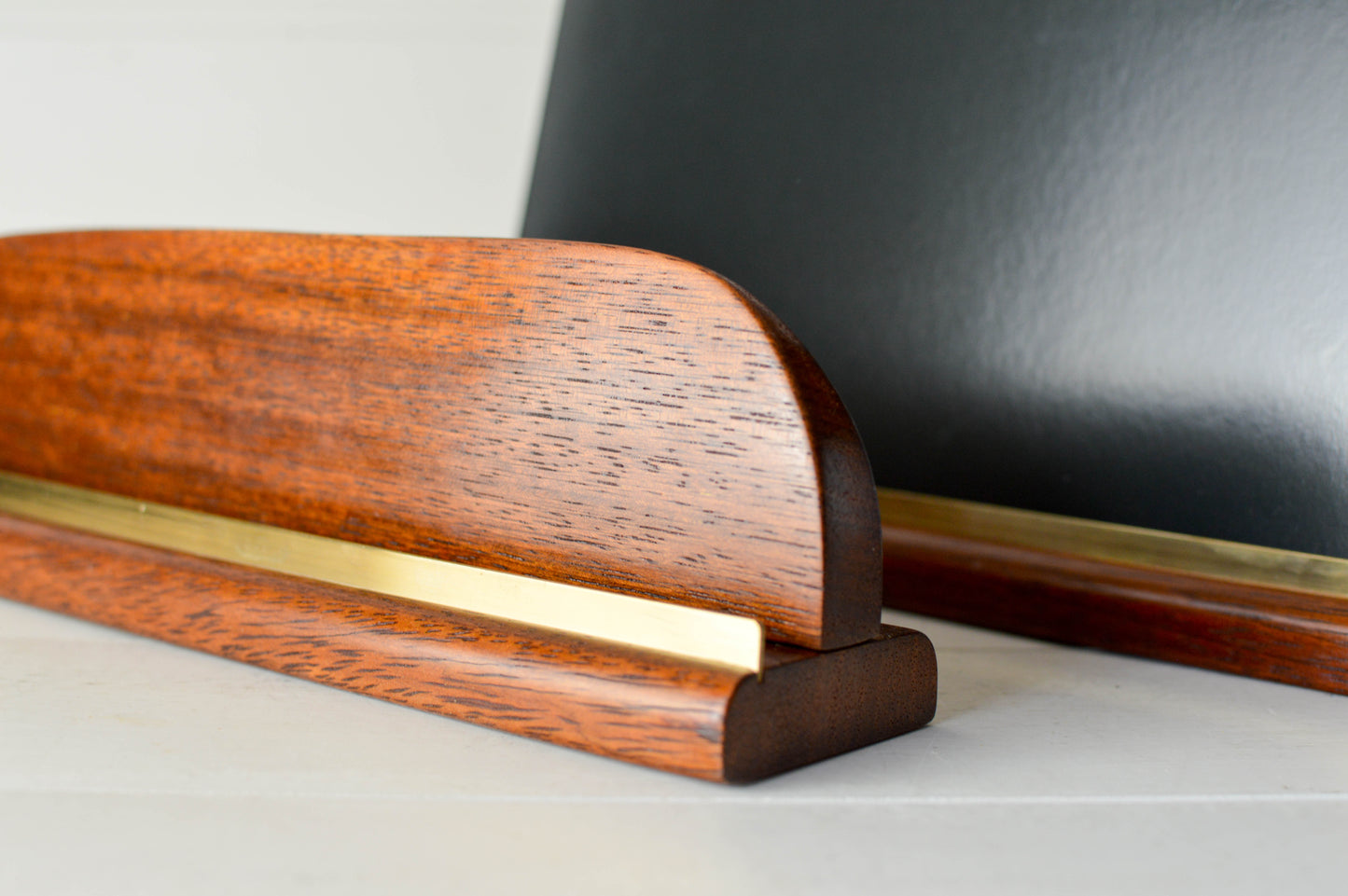 Minimalist vinyl record display stand in solid Merbau wood and brass. Holds 1–2 records. Handmade in Australia. $10 flat rate shipping nationwide.